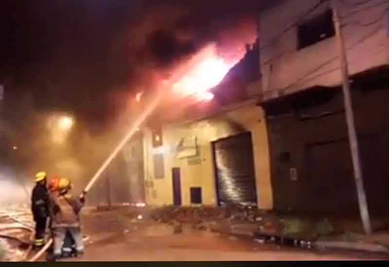 Bomberos trabajan para sofocar un incendio en un depósito