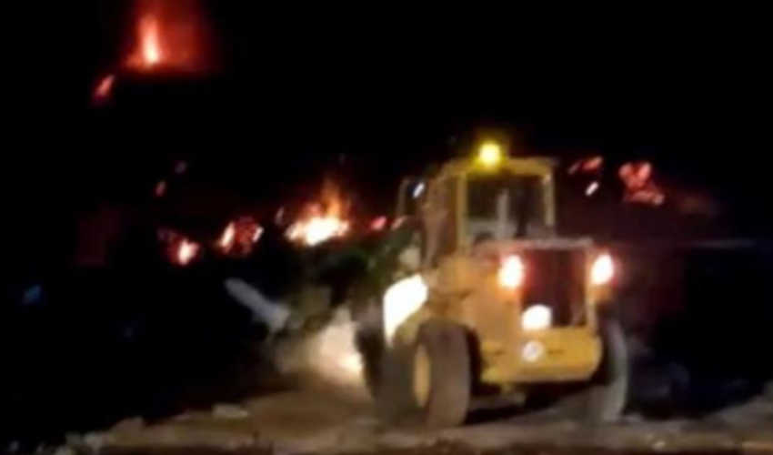 Bomberos intentan encauzar la lava con un tractor