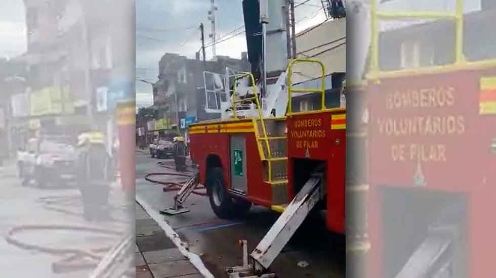 Bomberos trabajan para apagar un incendio en dos locales de Pilar